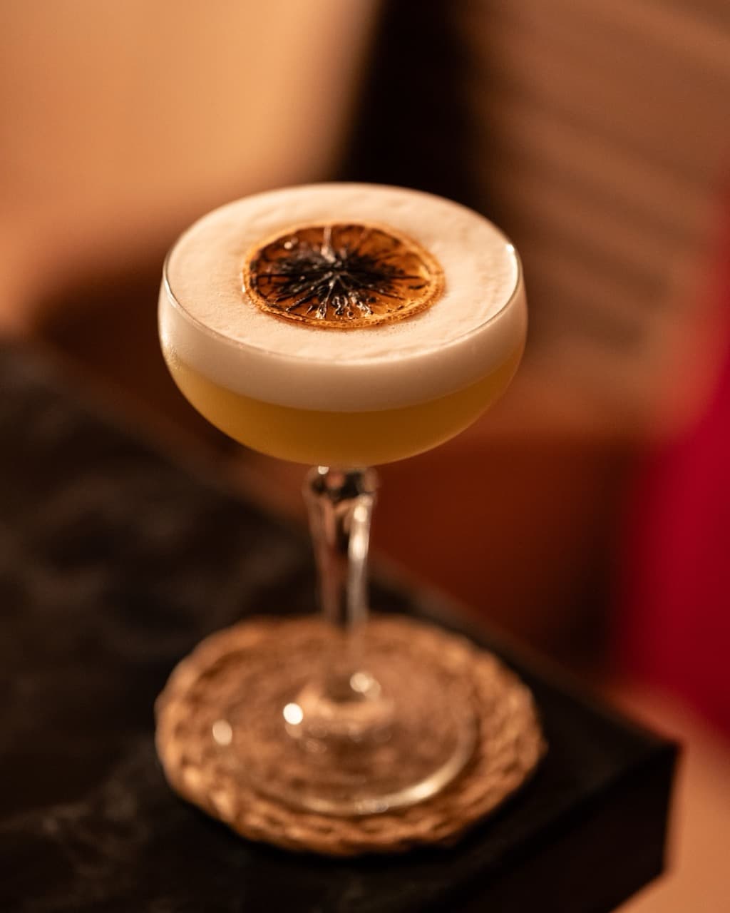 Pornstar martini glowing beside candles at The Apothecary