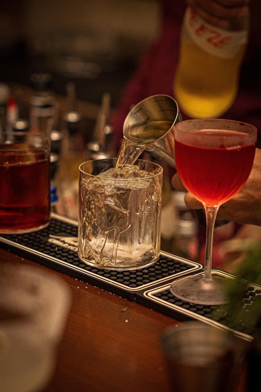Bartender pouring a cocktail at The Apothecary
